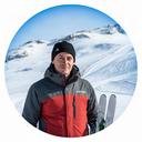 Ski instructor standing beside a marked alpine piste in fresh snow